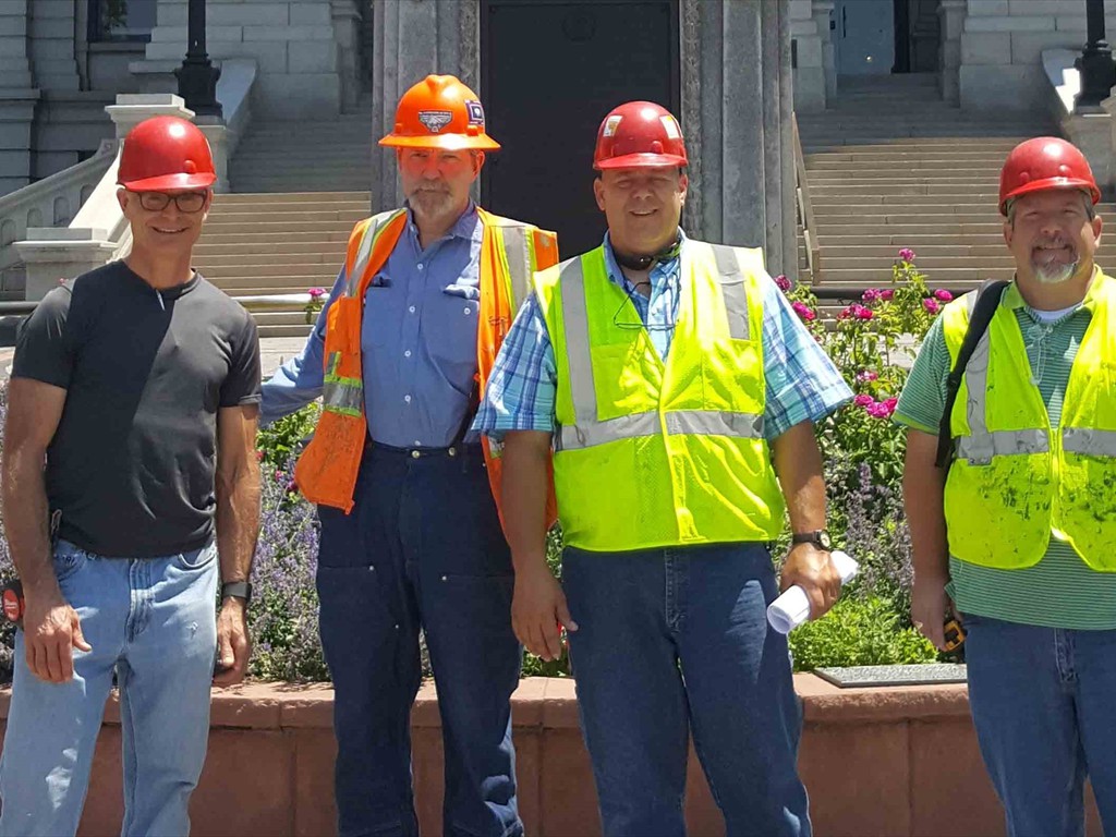 construction workers stand in front of their job site.