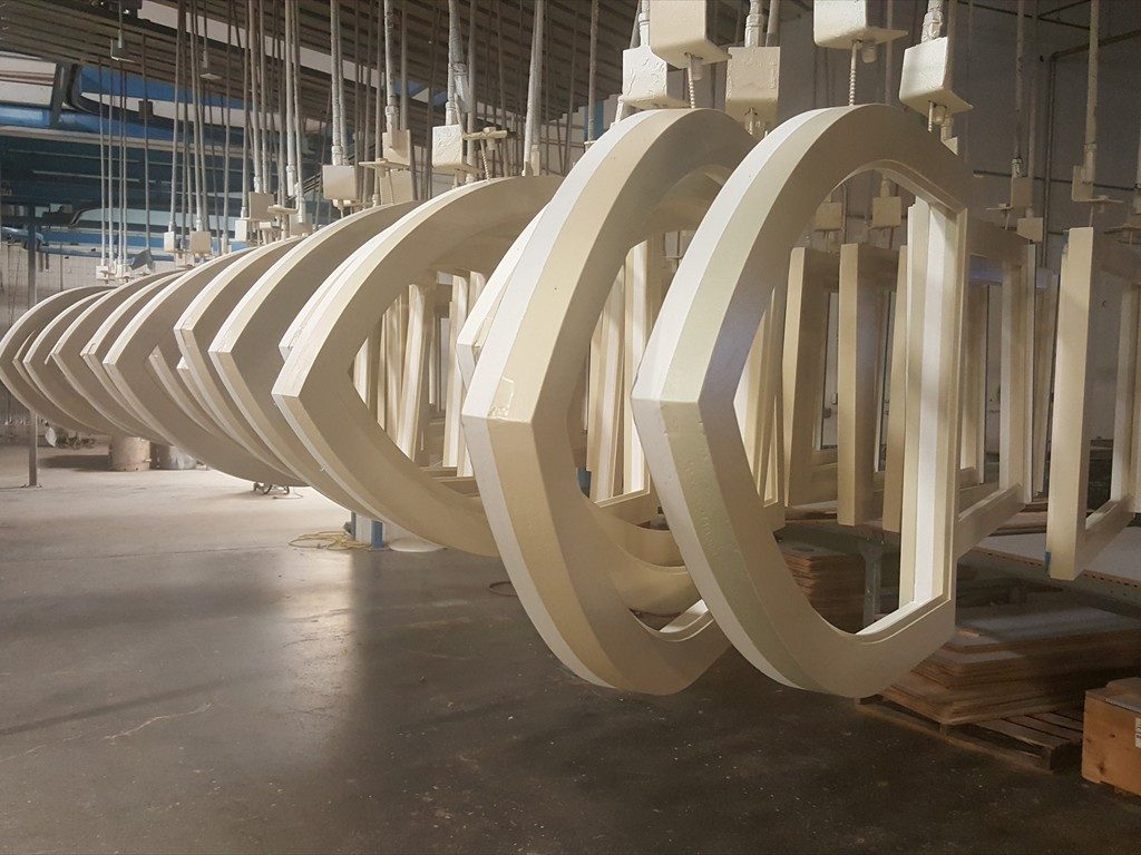 Arched windows hanging on the paint line.