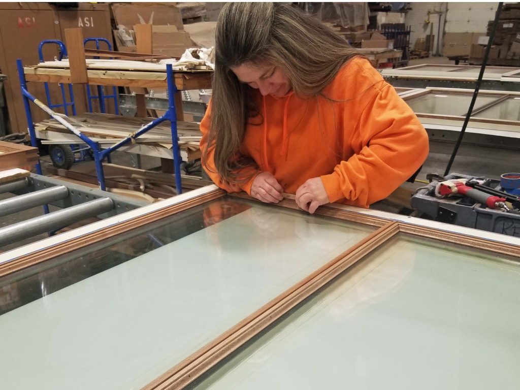 A Re-View employee works on a window frame during manufacturing.