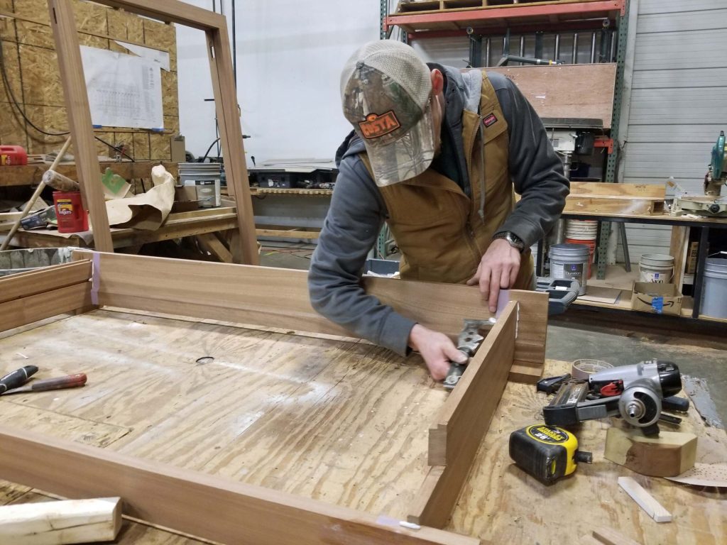 A Re-View employee works on a window frame during manufacturing.