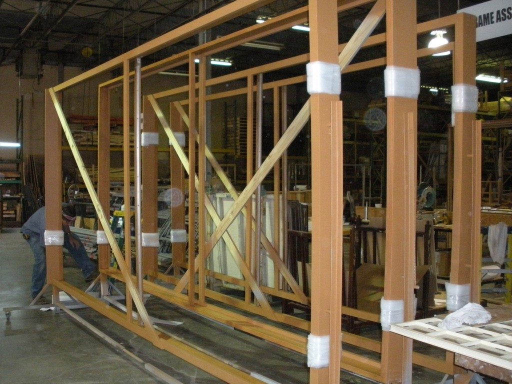 Large window frames sit in a warehouse prior to installation.