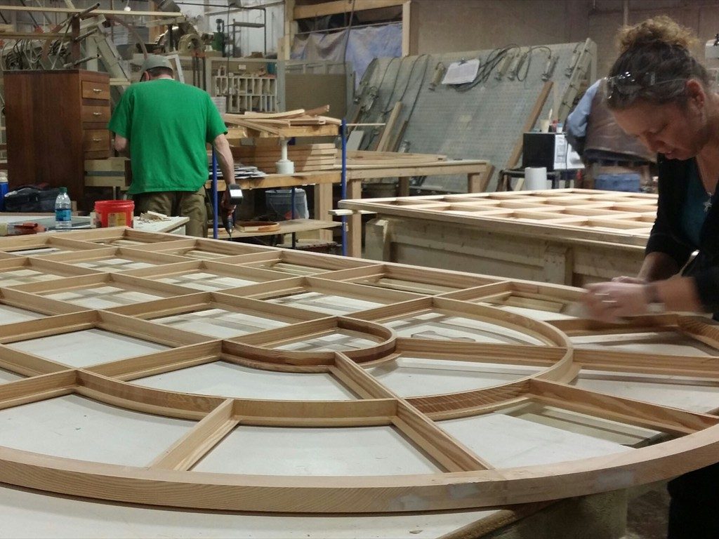 A worker prepares a monumental arch window for Dunster Hall.