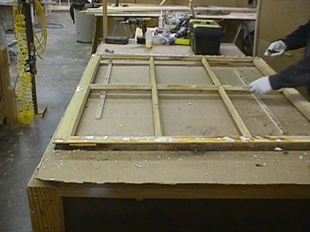 A worker preparing a window sash.