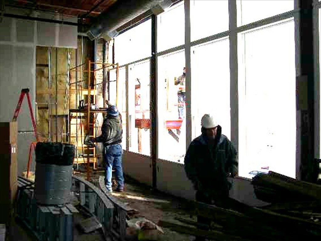 Workers using scaffolding and working on window frames.