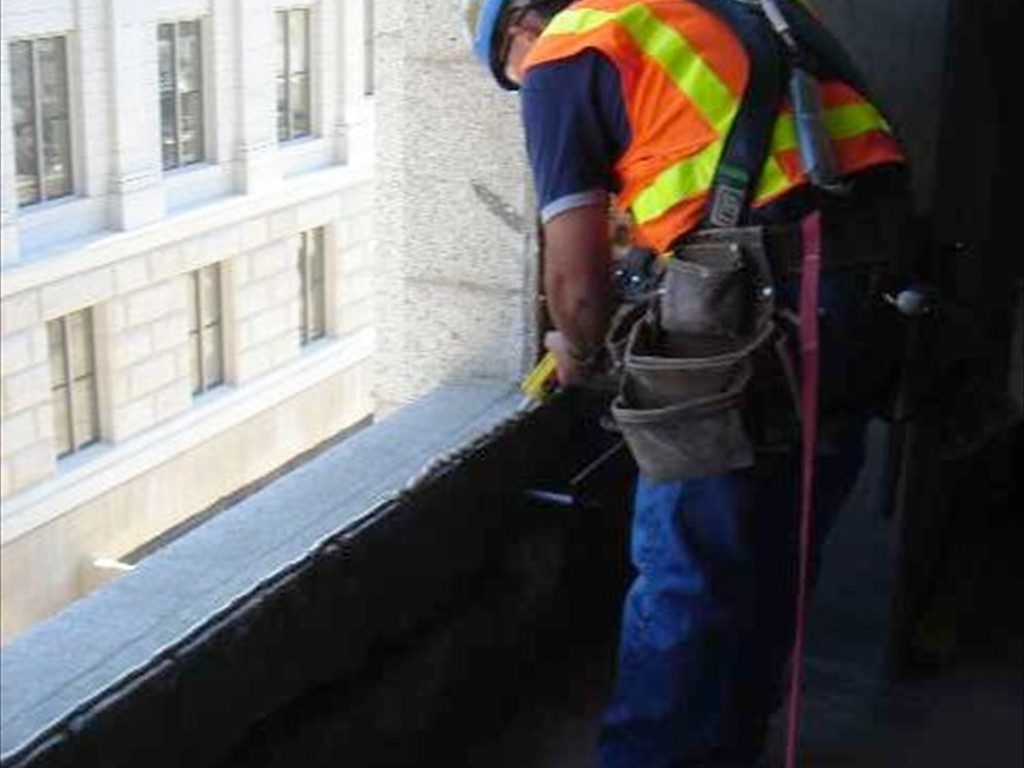 A worker preparing a window opening prior to installation.