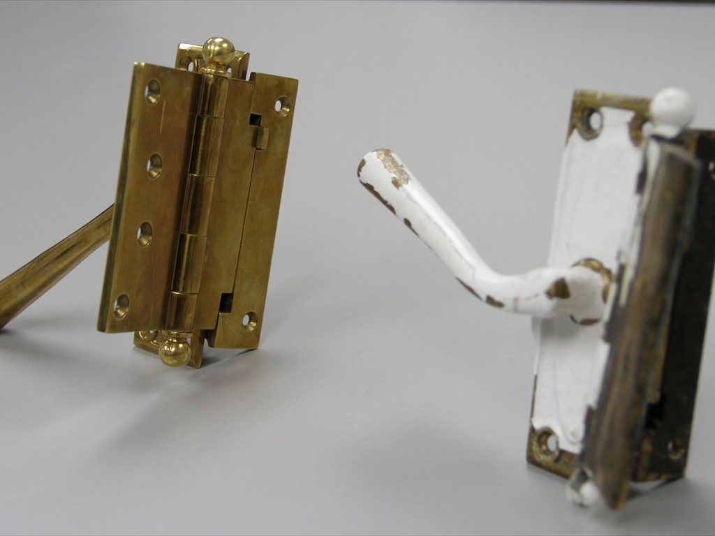 Vintage window hardware next to a custom replica.